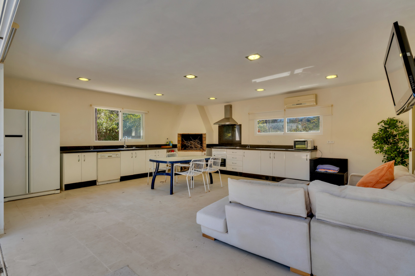 Großzügiger, 67 m² großer überdachter Grillbereich mit Einbauküche, gemauertem Kamin und Wohnzone, der sich ideal als separates Gästeapartment eignet.