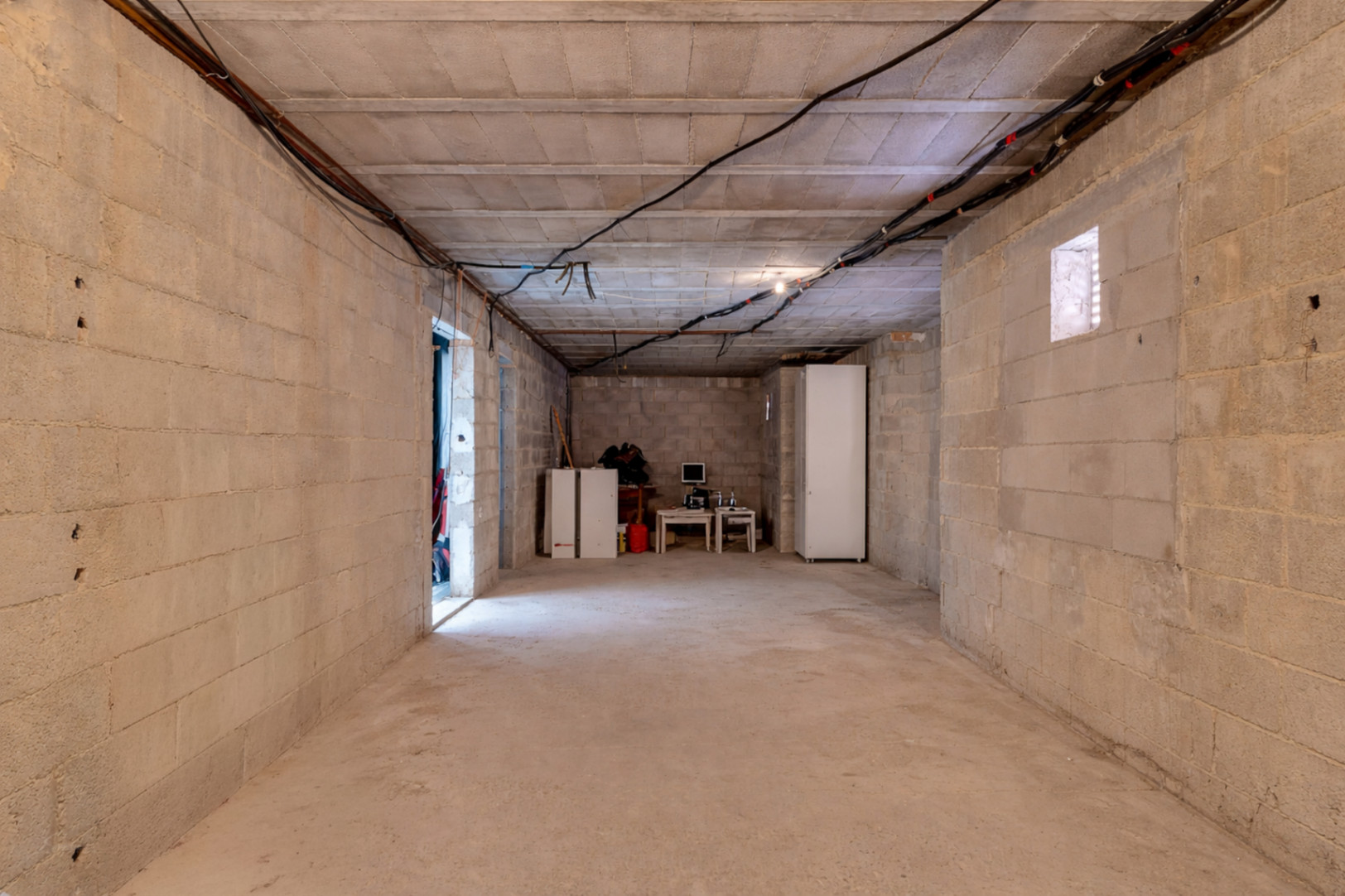 Großzügiger Untergeschoss-Rohbau mit Betonwänden und hohen Decken, der vielseitige Ausbaumöglichkeiten für Wohnraum oder einen Wellnessbereich bietet.