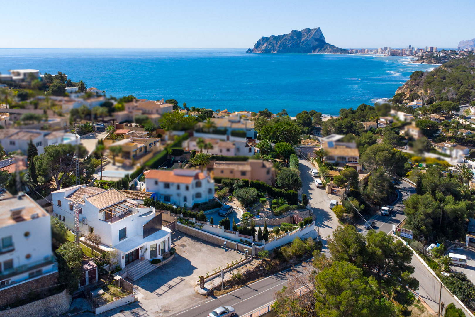 Luftaufnahme der Immobilie an der Küstenstraße mit weitem Blick auf das Mittelmeer und den markanten Peñón de Ifach im Hintergrund.