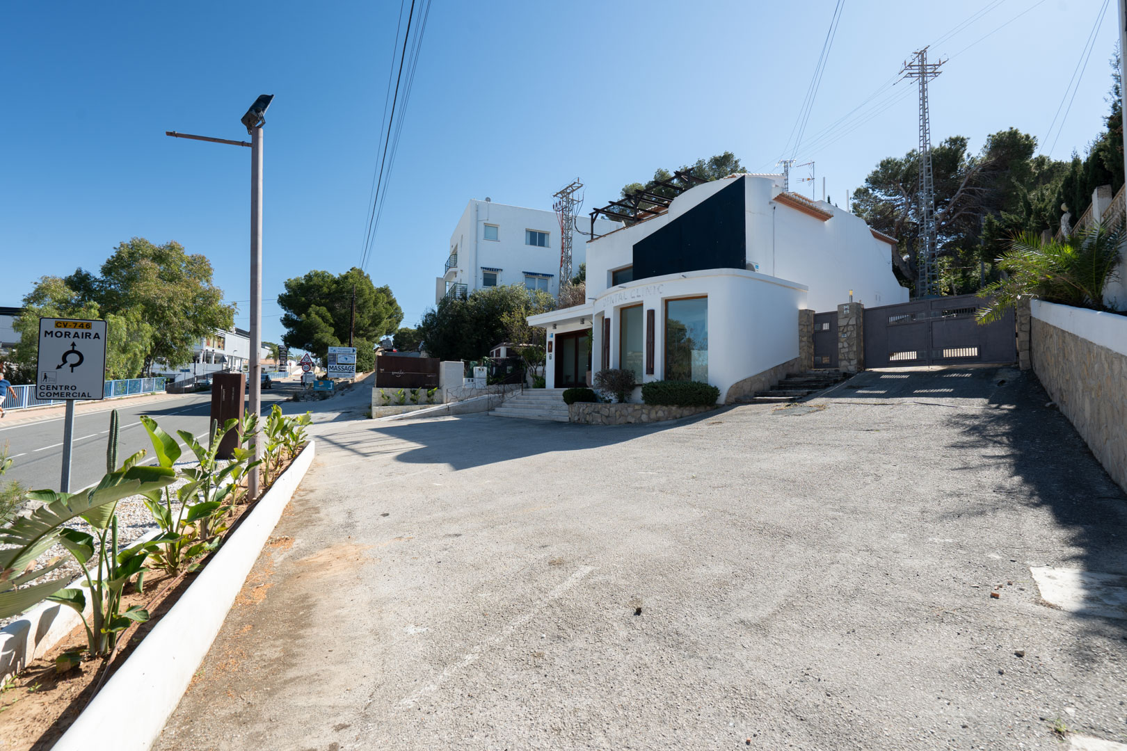 Moderne Außenfassade mit großen Schaufenstern, großzügigem Privatparkplatz und direktem Zugang von der Hauptstraße Moraira-Calpe.