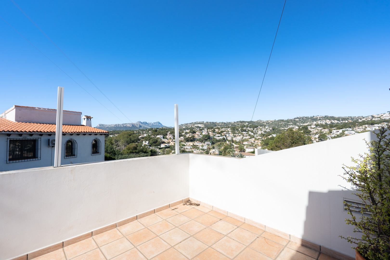Terrasse mit Keramikfliesen und weitem Panoramablick auf das Sierra de Bernia-Gebirge und die umliegende Wohngegend.