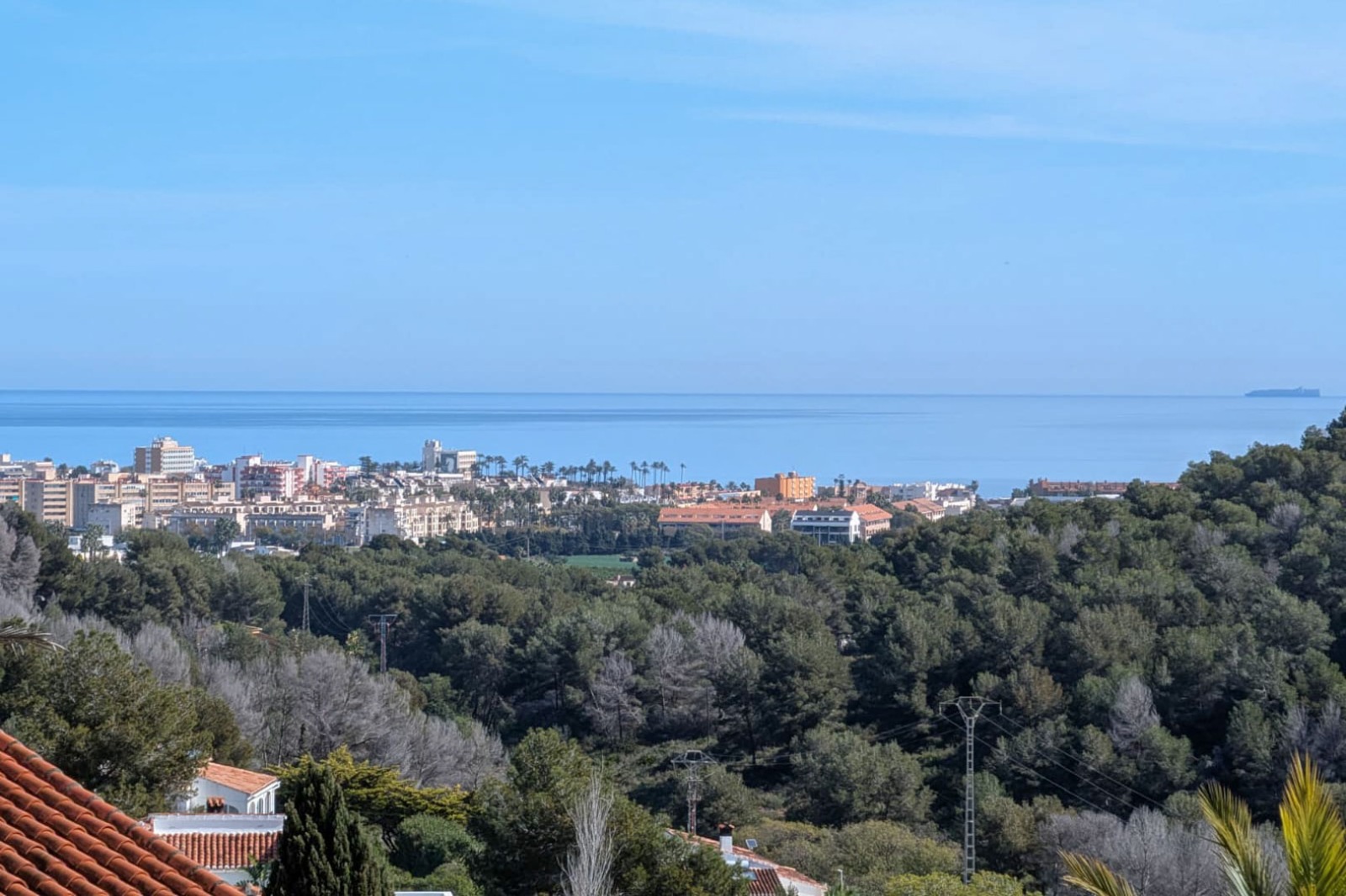 Erhöhter Panoramablick vom Grundstück auf das Mittelmeer, die Küstenbebauung von Jávea und die umliegenden bewaldeten Hügel.