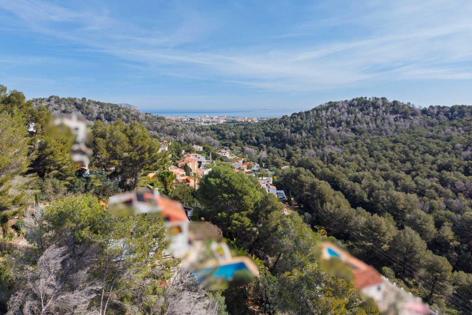 Panoramablick vom Grundstück über pinienbewachsene Hügel bis hin zum Mittelmeer und der Küstenstadt Jávea am Horizont.