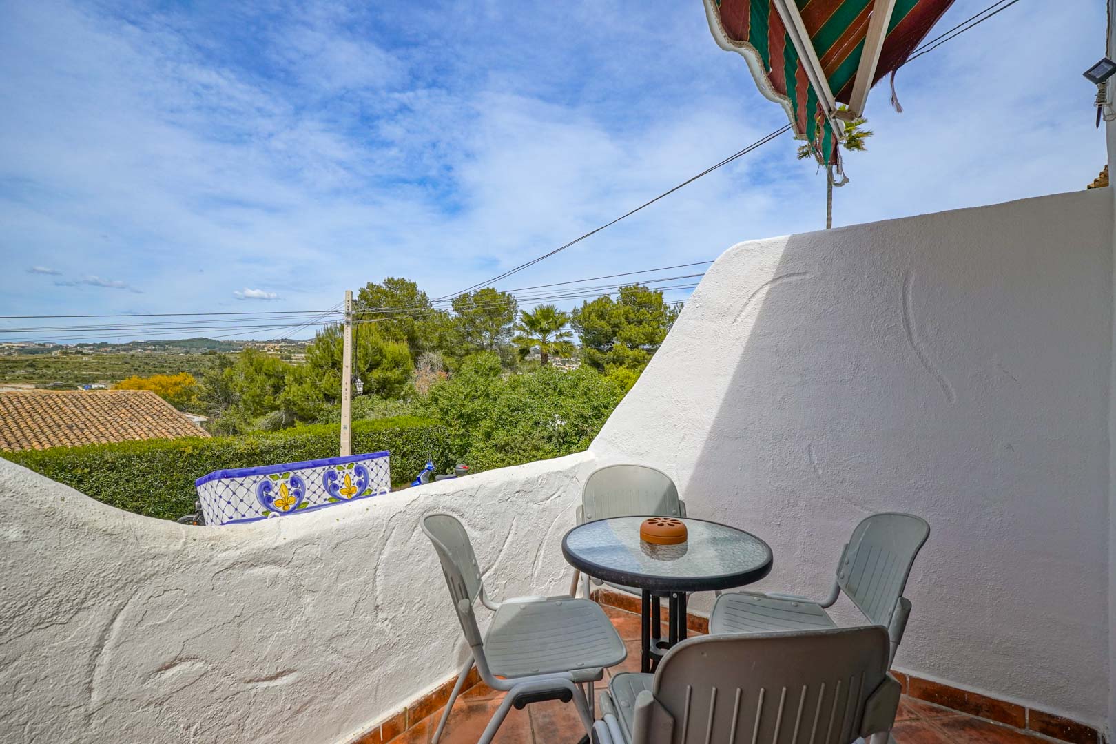 Außenterrasse mit Terrakottaboden und Sitzgruppe, die einen weiten Blick über das Tal und die mediterrane Landschaft von Moraira bietet.