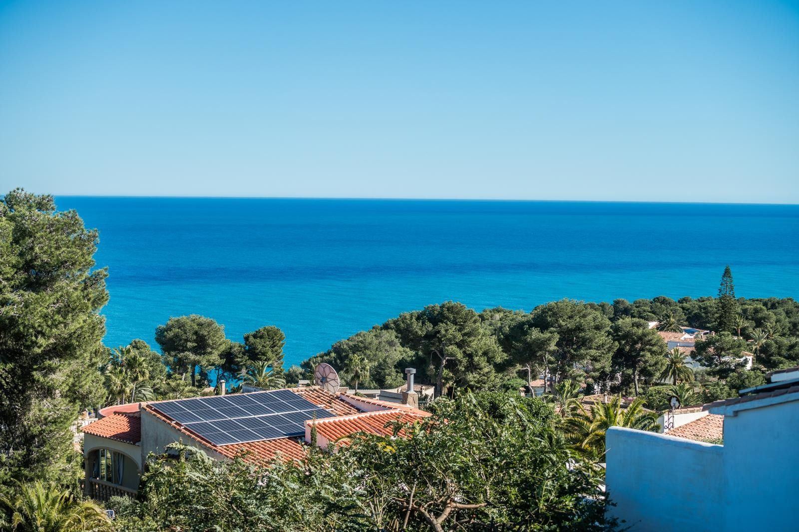 Panoramablick auf das Mittelmeer von Balcón al Mar aus, über Pinienwälder und Hausdächer mit installierten Solaranlagen zur Energiegewinnung.