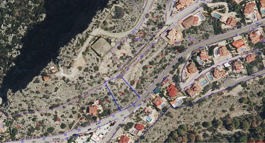 Luftaufnahme des blau umrandeten Stadtgrundstücks, gelegen an der Straße 'ROMER' innerhalb der Urbanisation Monte Pedreguer. Das unbebaute Gelände ist von bestehenden Wohnimmobilien umgeben.