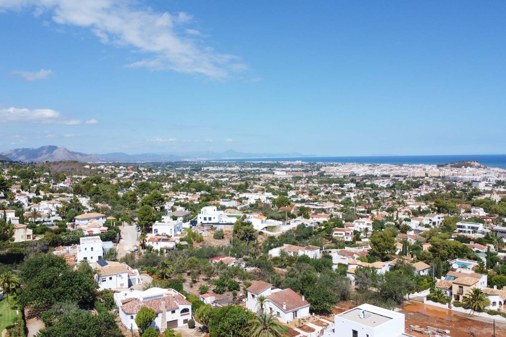 Panorama-Luftaufnahme des Wohngebiets in Dénia mit weitem Blick auf das Mittelmeer und die charakteristische Architektur der Costa Blanca.