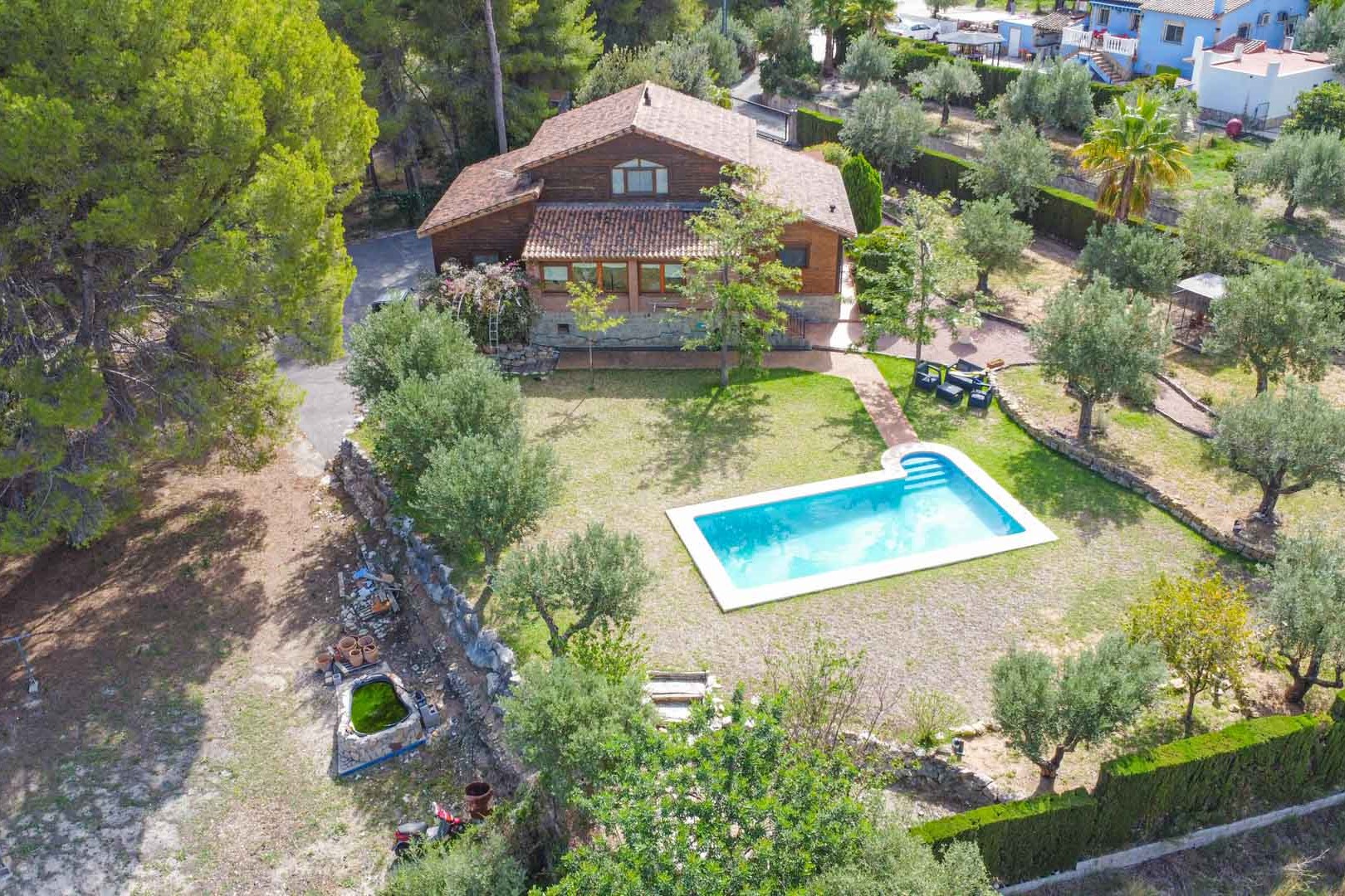 Luftaufnahme der Villa aus finnischem Kiefernholz mit privatem Pool, umgeben von mediterranen Gärten mit Olivenbäumen und Pinien in Orba.