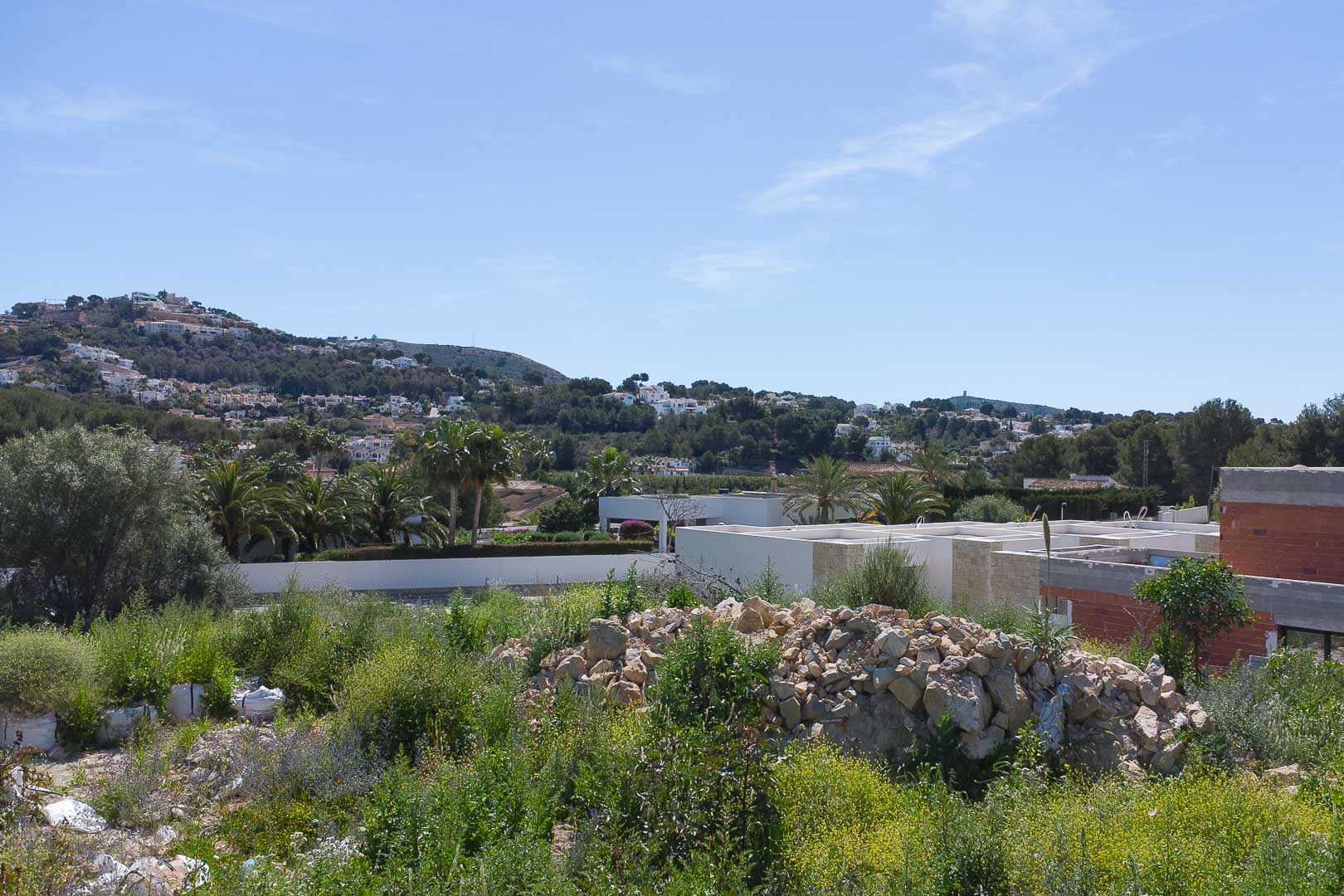 Panoramablick vom Baugrundstück auf die Hügel von Moraira mit der natürlichen Umgebung und den umliegenden Villen.