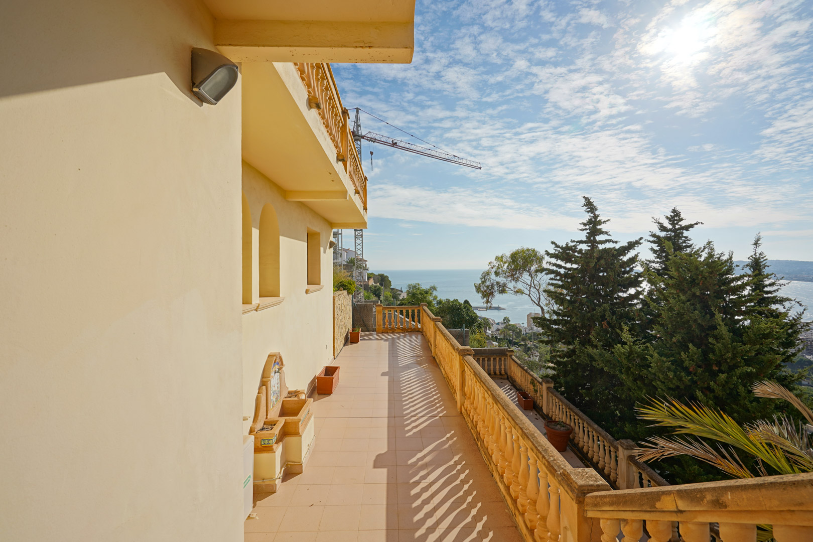 Lange Terrasse mit traditioneller Balustrade, dekorativem Wandbrunnen und Panoramablick über das Mittelmeer und die Küste von Jávea.