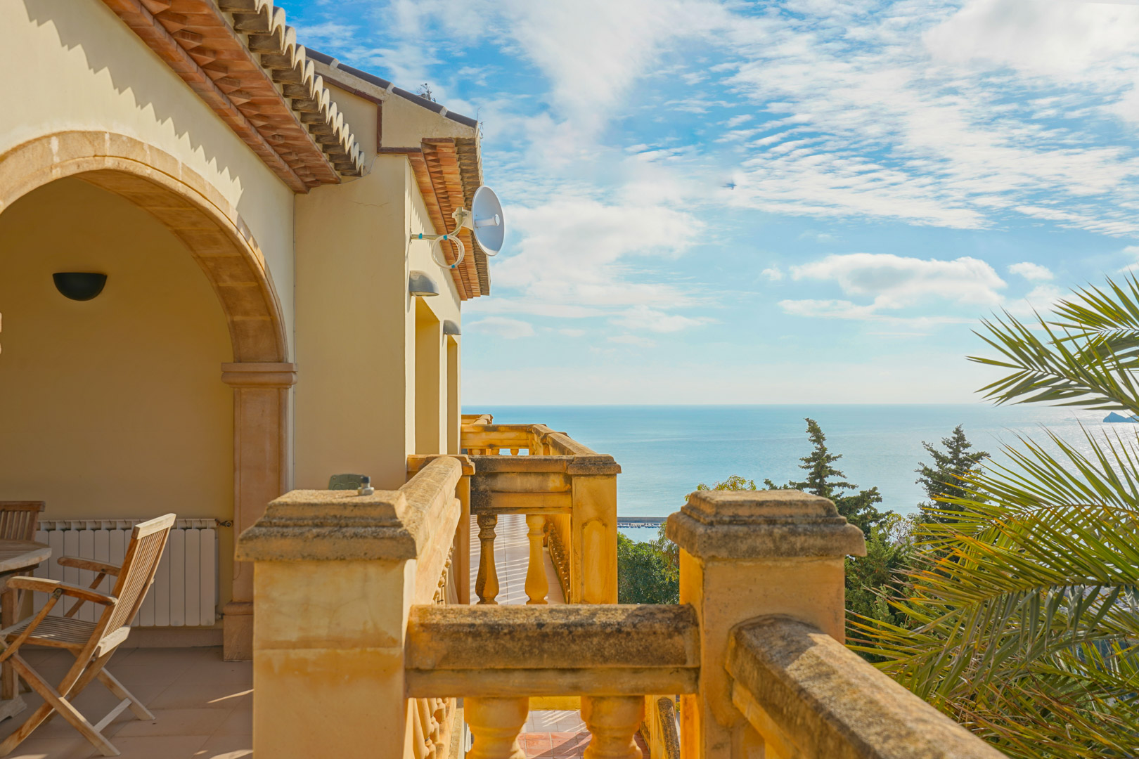 Obere Terrasse mit Steinbalustraden und traditionellen Rundbögen, die einen weiten Blick über das Mittelmeer und die Küste von Jávea bietet.
