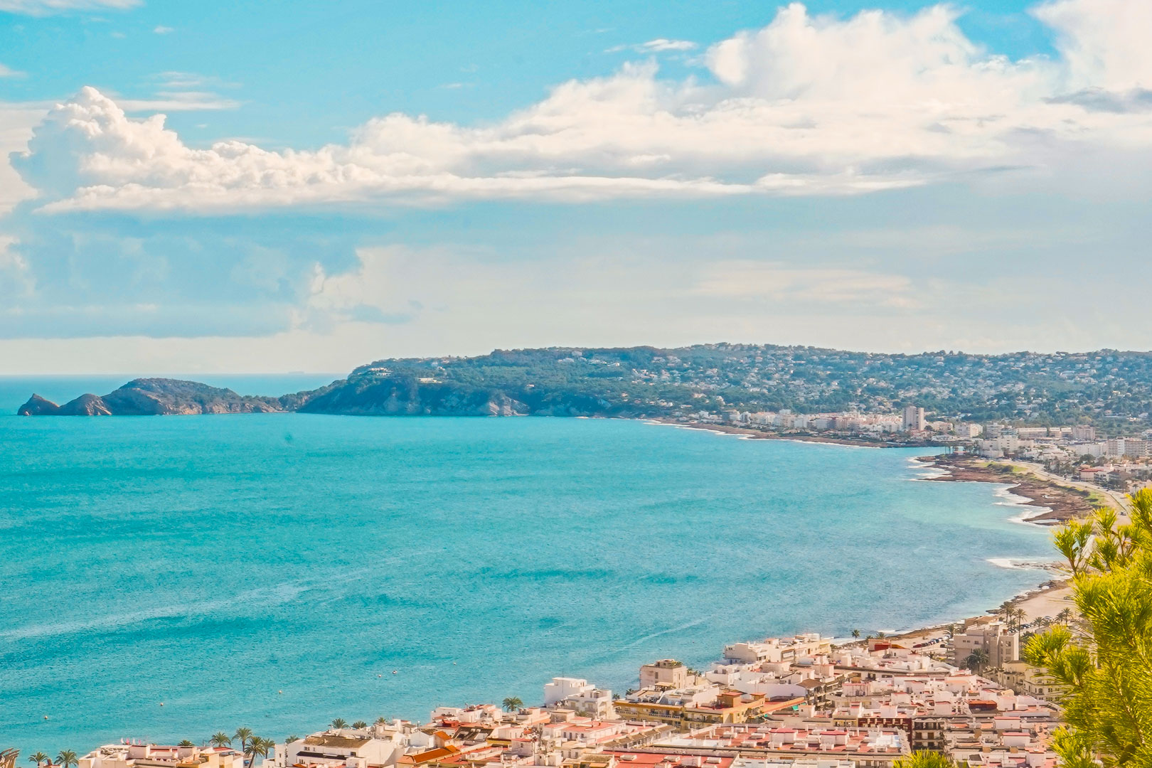 Panoramablick auf die Bucht von Jávea von La Corona aus, mit Blick auf die Küstenbebauung und die Landzunge Cap Negre am türkisfarbenen Mittelmeer.