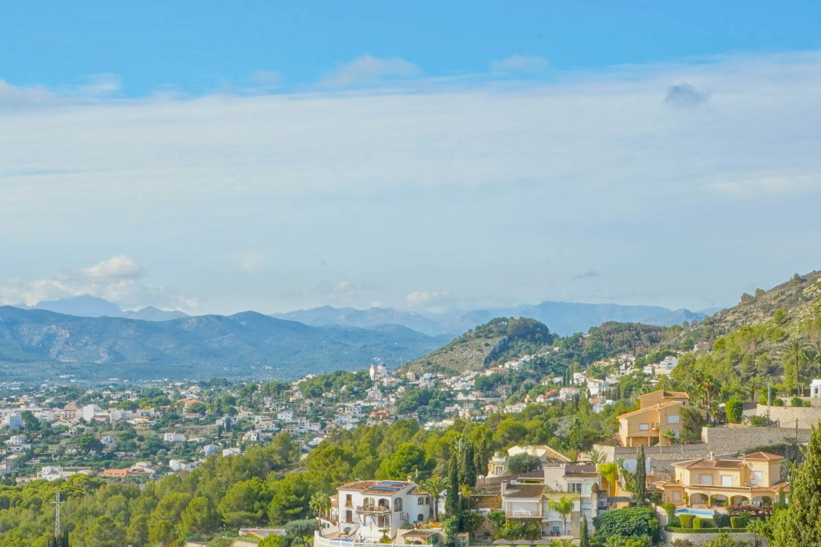 Panoramablick vom Anwesen über das Tal und die umliegenden Gebirgsketten, der die mediterrane Vegetation und die Wohnlandschaft von Jávea zeigt.