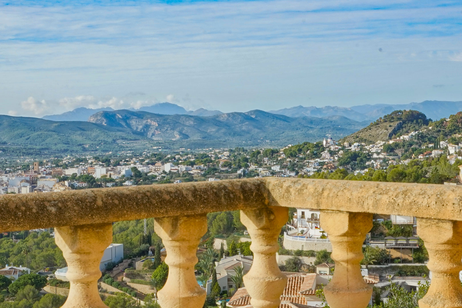 Panoramablick von der Terrasse mit traditioneller Steinbalustrade auf das Tal von Jávea und die umliegenden Gebirgsketten.