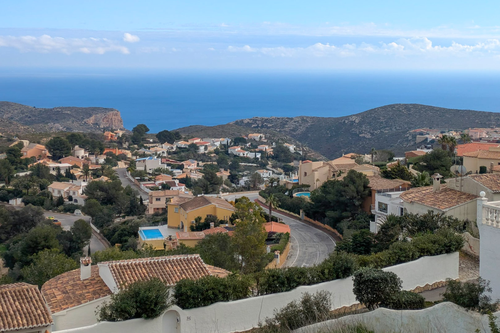 Panoramablick von Cumbre del Sol auf das Mittelmeer, mit der gewachsenen Wohngegend und der zerklüfteten Küstenlandschaft der Costa Blanca.