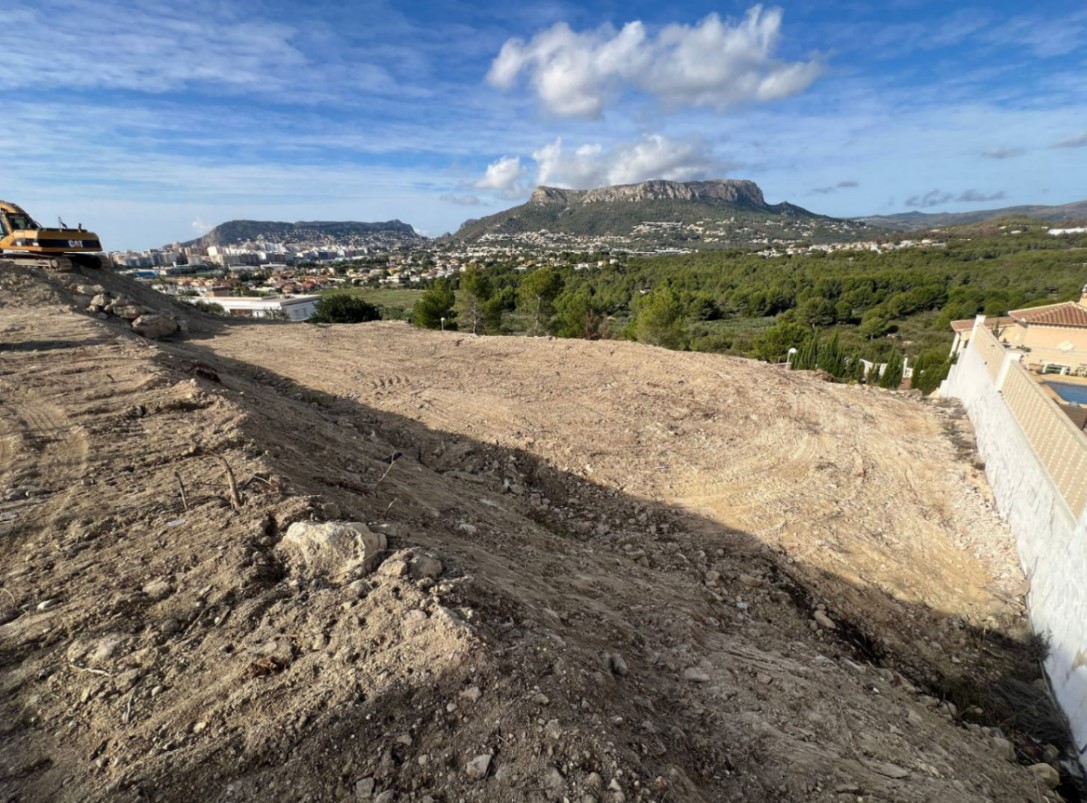 Baugrundstück in der Erschließungsphase mit weitem Blick auf den Peñón de Ifach, das Stadtgebiet von Calpe und die umliegenden Berge.