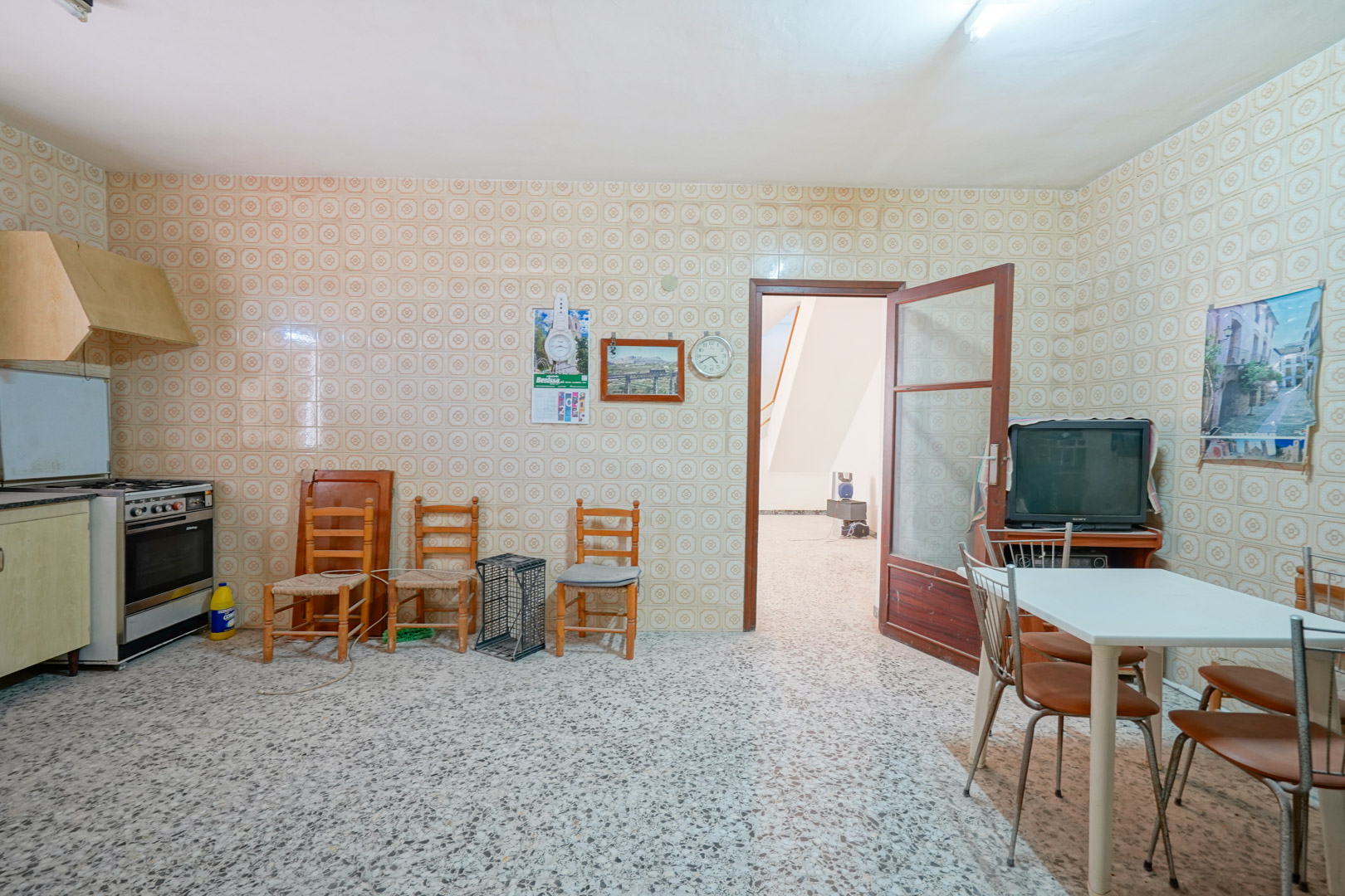 Traditionelle Küche mit gemusterten Wandfliesen im Vintage-Stil, Terrazzoboden und einem Essbereich mit Zugang zum Hauptflur.