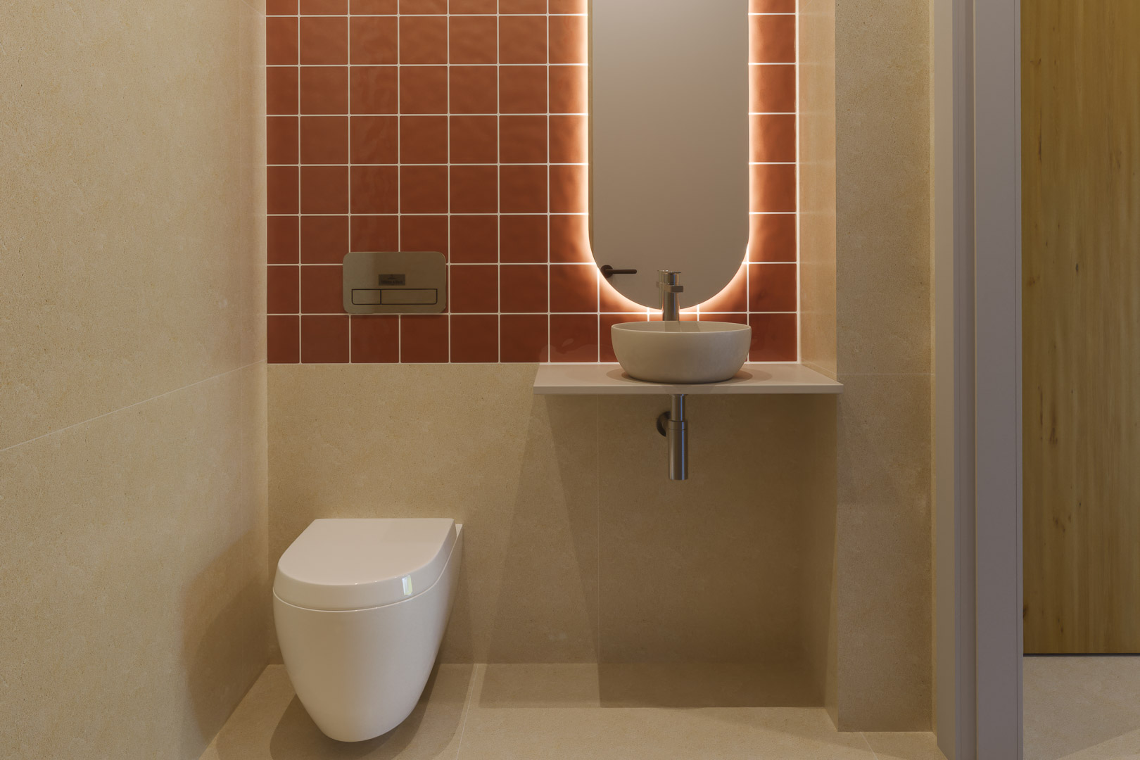 Gäste-WC mit terrakottafarbenen Fliesen, wandhängendem WC und minimalistischem Waschbecken. Ein hinterleuchteter ovaler Spiegel sorgt für sanftes Licht.