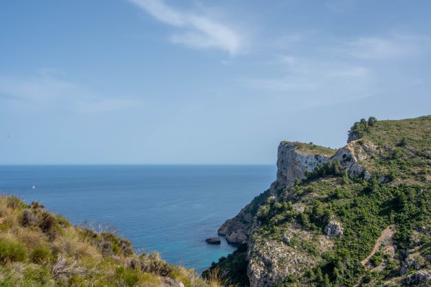 Panoramablick auf die mediterranen Küstenfelsen und das blaue Meer in der natürlichen Umgebung von Cumbre del Sol.