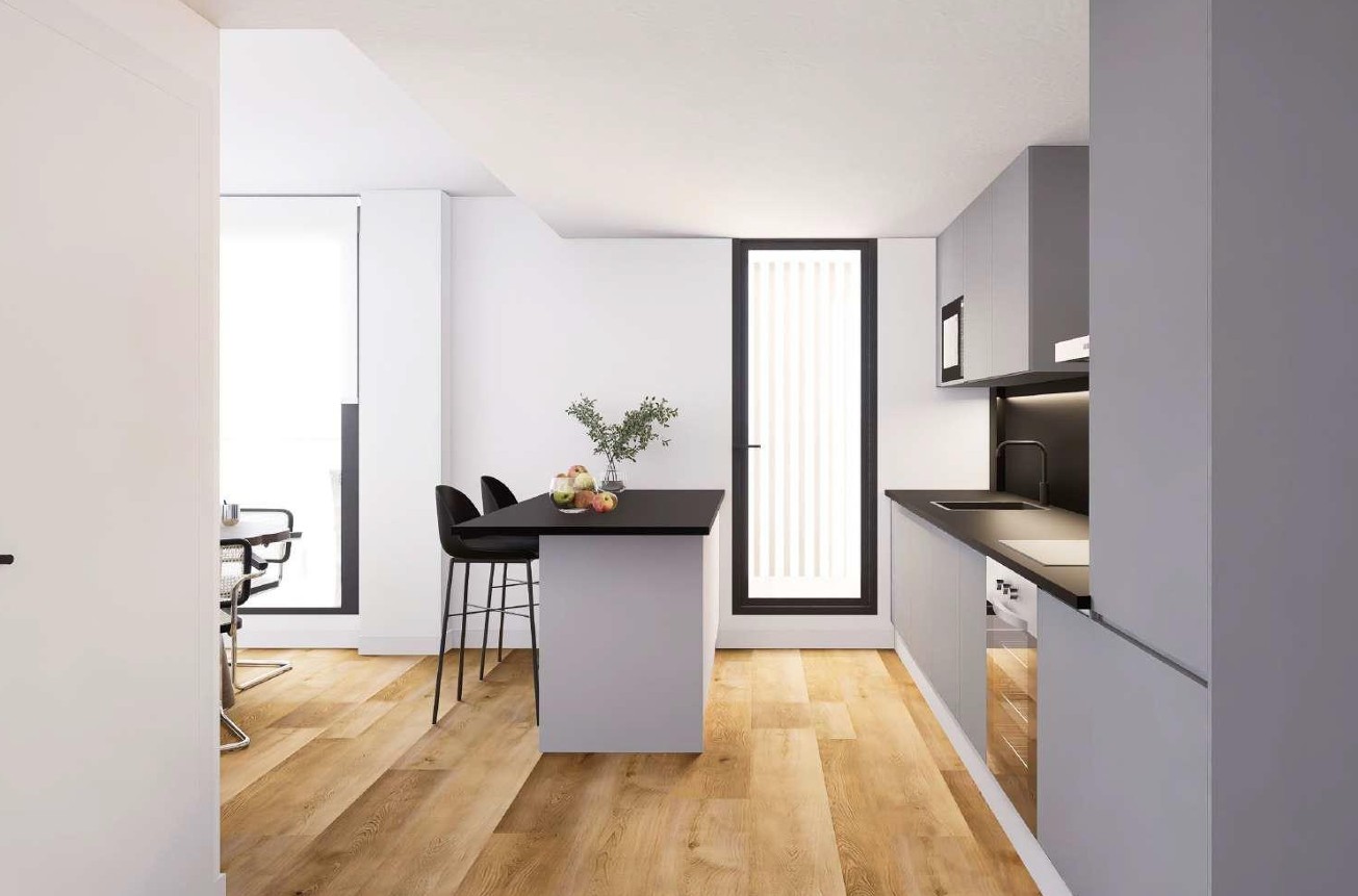 Moderne Küche mit Kochinsel, schwarzer Arbeitsplatte und Barhockern. Ausgestattet mit grauen Schränken, integrierten Geräten und hellem Bodenbelag in Holzoptik von Porcelanosa.