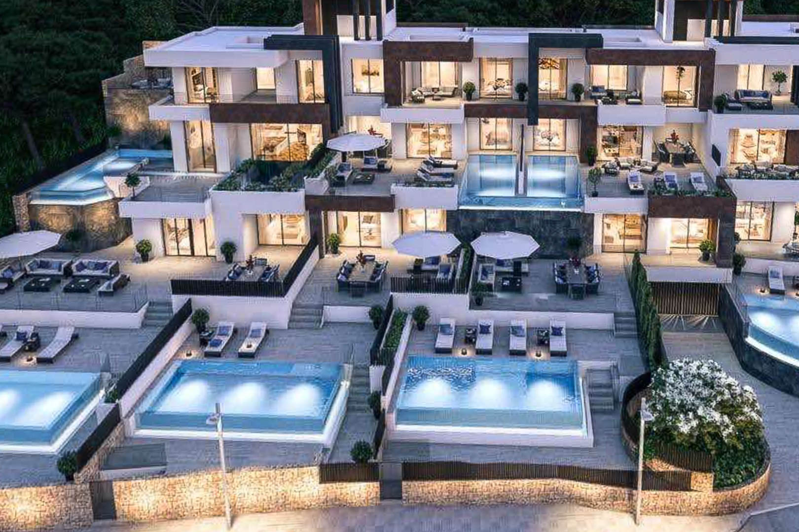 Außenansicht einer modernen Wohnanlage mit abgestuften Terrassen, beleuchteten Privatpools und Fassaden aus Naturstein und weißen Elementen.