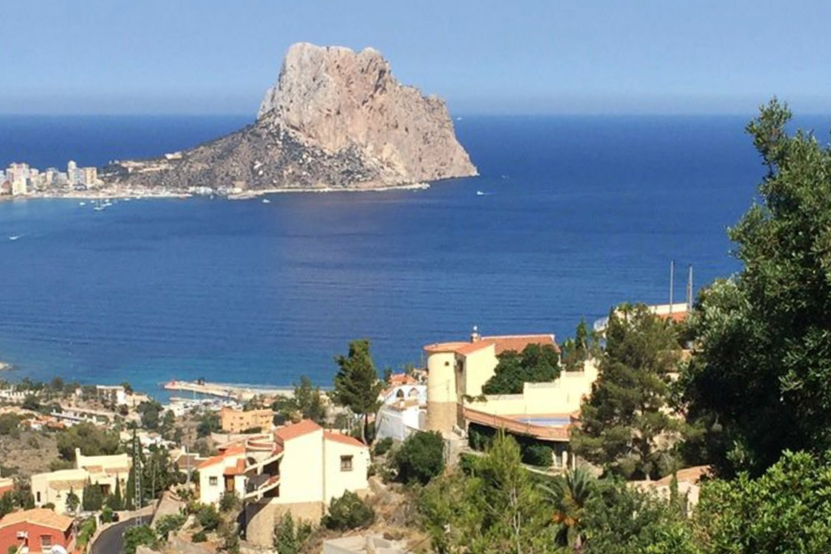 Erhöhter Panoramablick auf den Peñón de Ifach und das Mittelmeer, über die Wohnlandschaft und die üppige Vegetation von Calpe.