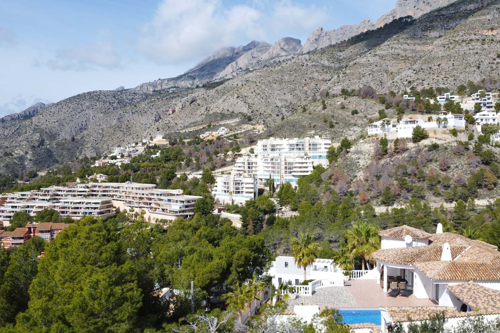 Luftansicht der mediterranen Villa mit Pool, die ihre exklusive Lage am Fuße des majestätischen Sierra de Bernia Gebirgszuges zeigt.