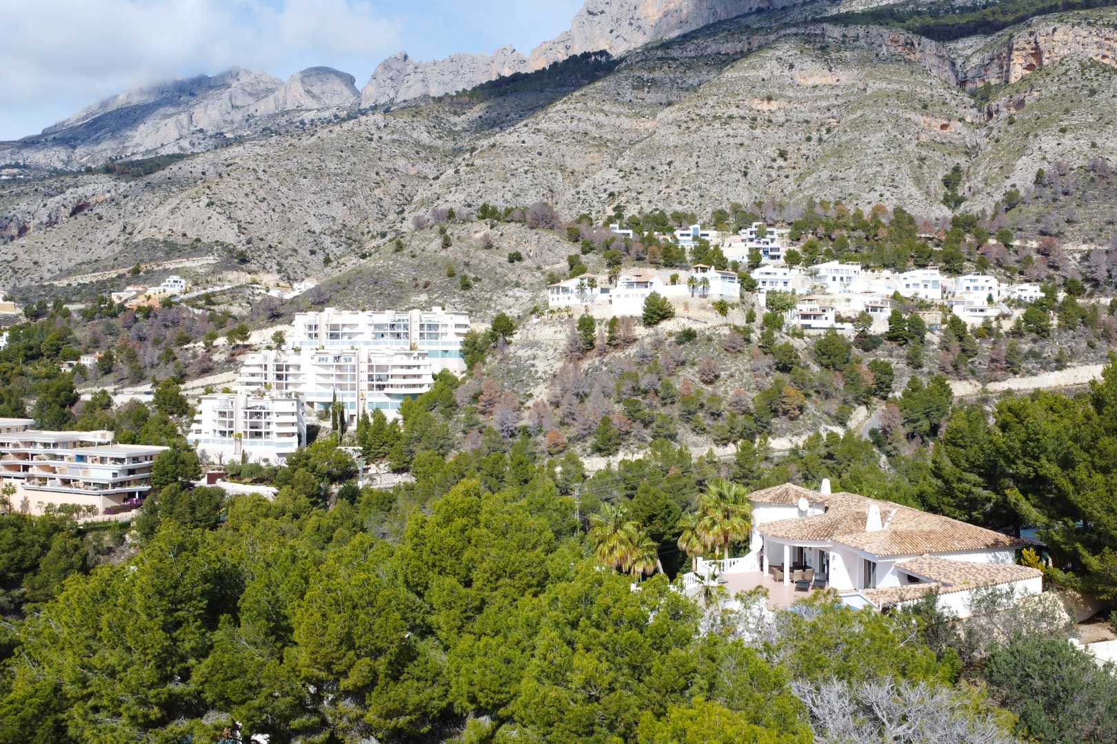 Luftaufnahme der mediterranen Villa mit Ziegeldach, eingebettet in Pinienwälder am Fuße des Sierra de Bernia Gebirges in Altea.