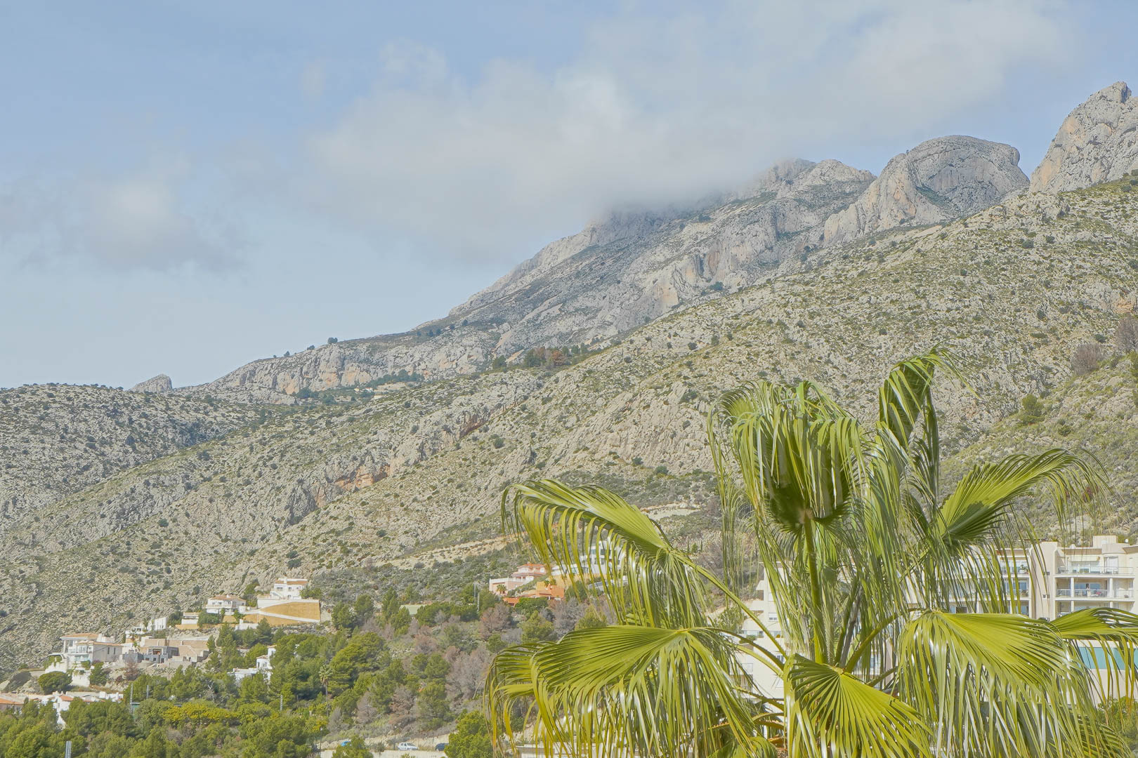 Panoramablick auf das Sierra de Bernia-Gebirge mit seinen markanten Kalksteinfelsen und mediterraner Flora, aufgenommen vom Außenbereich der Villa.