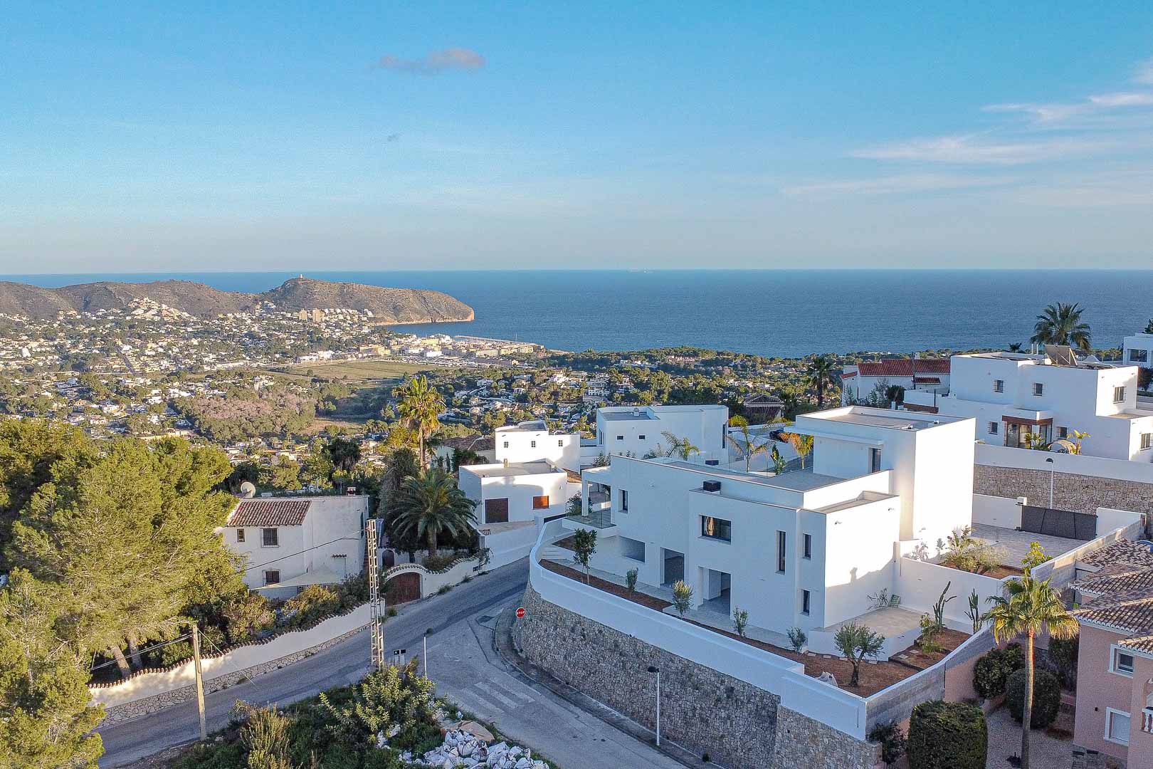 Erhöhte Ansicht moderner weißer Villen in Benimeit mit Panoramablick auf das Meer und die Küste.