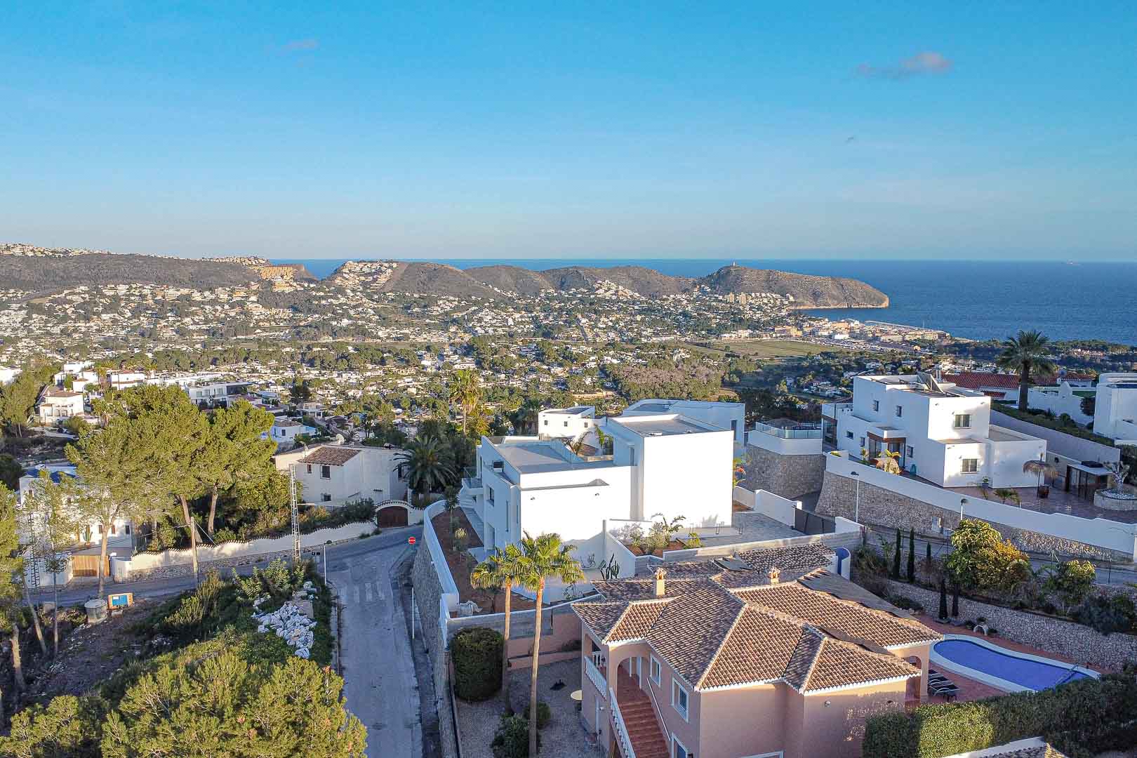 Luftaufnahme einer modernen Villa in Benimeit mit Panoramablick auf das Meer und die Küste.