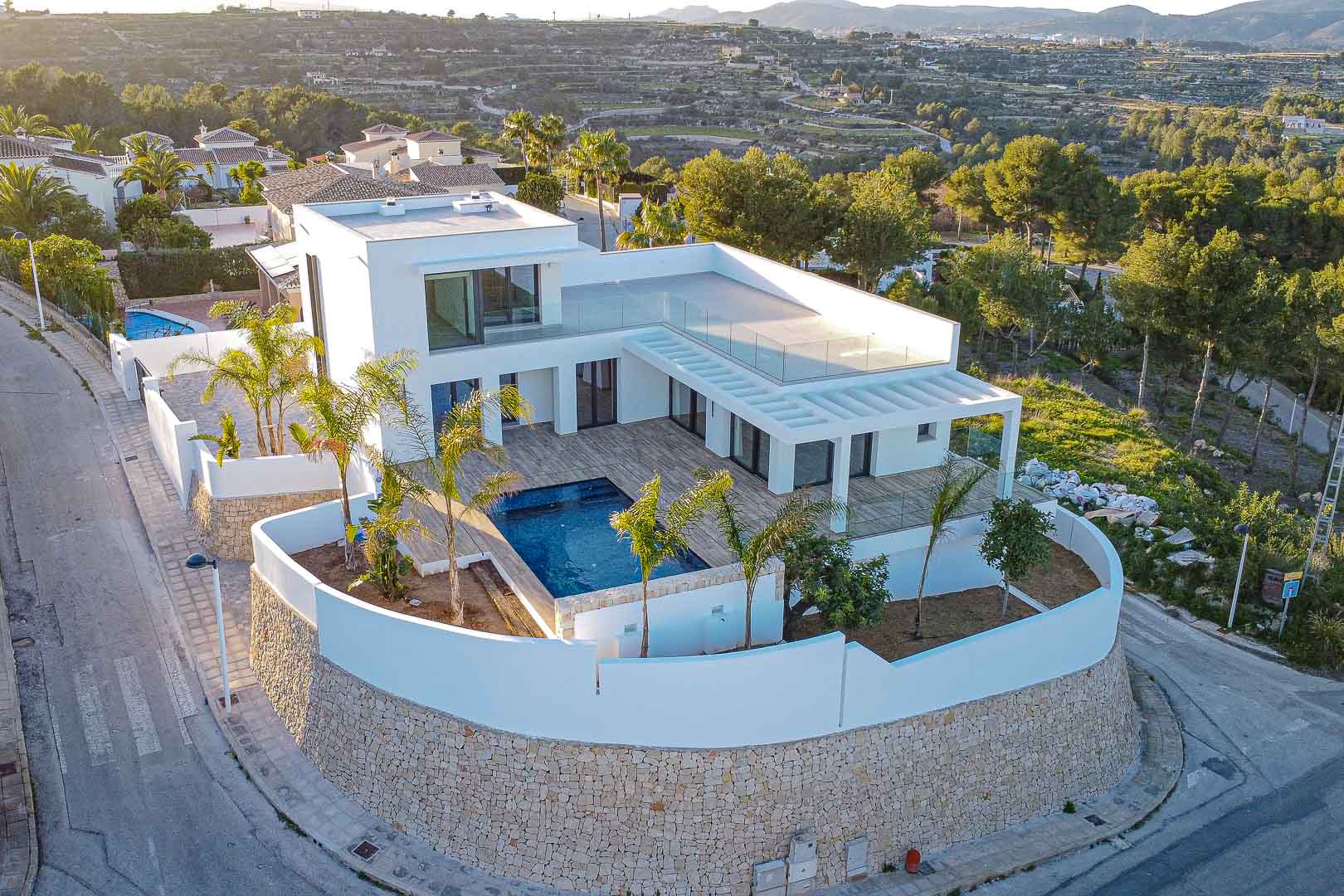 Luftaufnahme einer modernen Villa mit Pool, Terrassen und mediterranem Garten in Benimeit, Moraira.