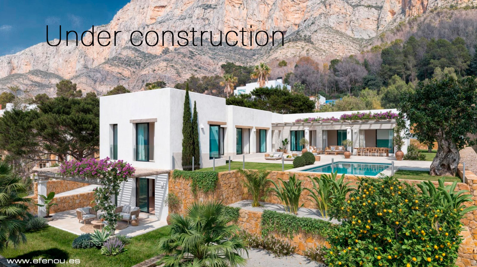 Außenansicht der Villa mit weißer Fassade, Pool und Natursteinmauern, gelegen vor der markanten Felskulisse des Montgó-Massivs in Jávea.