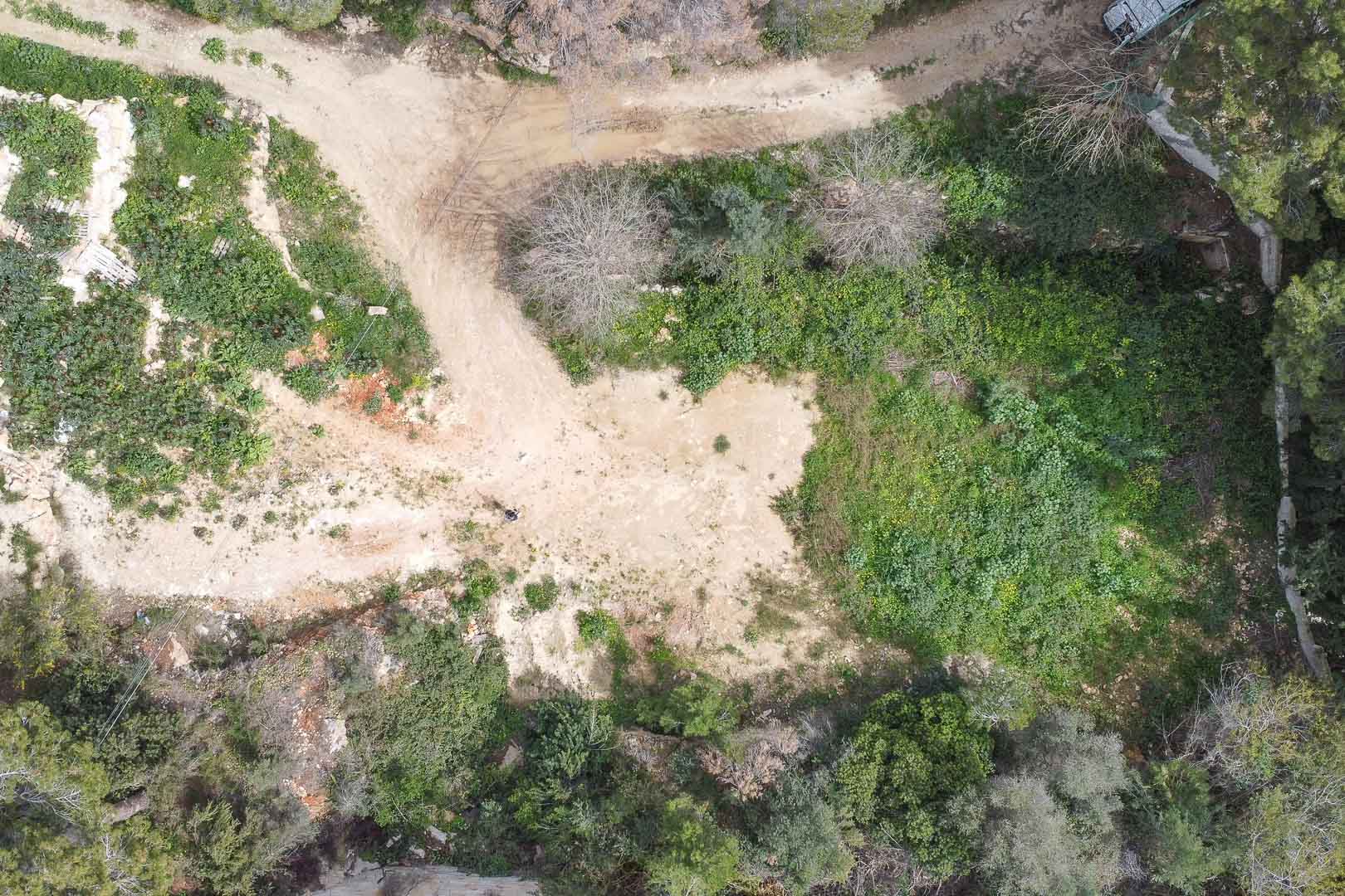 Luftaufnahme des Baugrundstücks aus der Vogelperspektive, umgeben von mediterraner Vegetation und bereit für die Realisierung des maßgeschneiderten Villenprojekts.