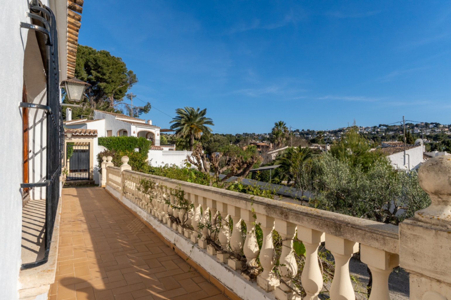 Außen-Terrasse mit traditionellen Terrakotta-Fliesen und klassischer Balustrade mit Blick auf die Wohngegend Cap Martí in Jávea.