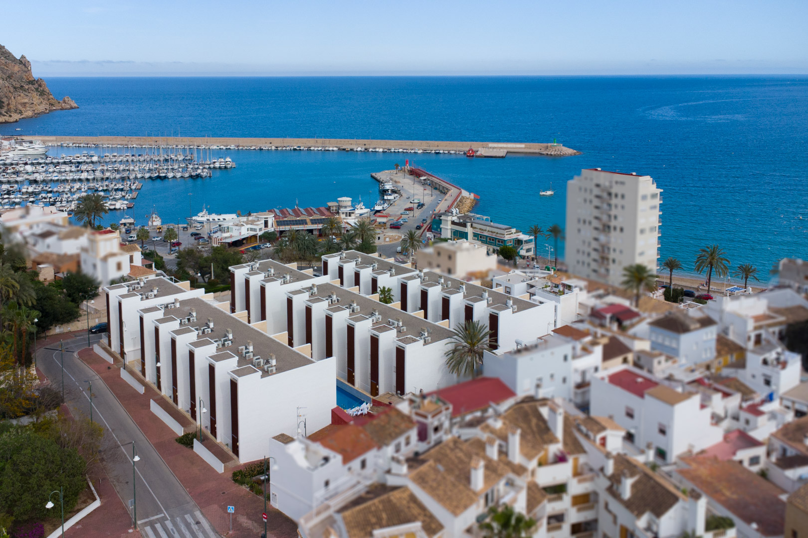 Luftaufnahme des Hafens von Jávea und moderner Wohnanlagen am Mittelmeer, die die erstklassige Lage der Immobilie an der Küste verdeutlicht.
