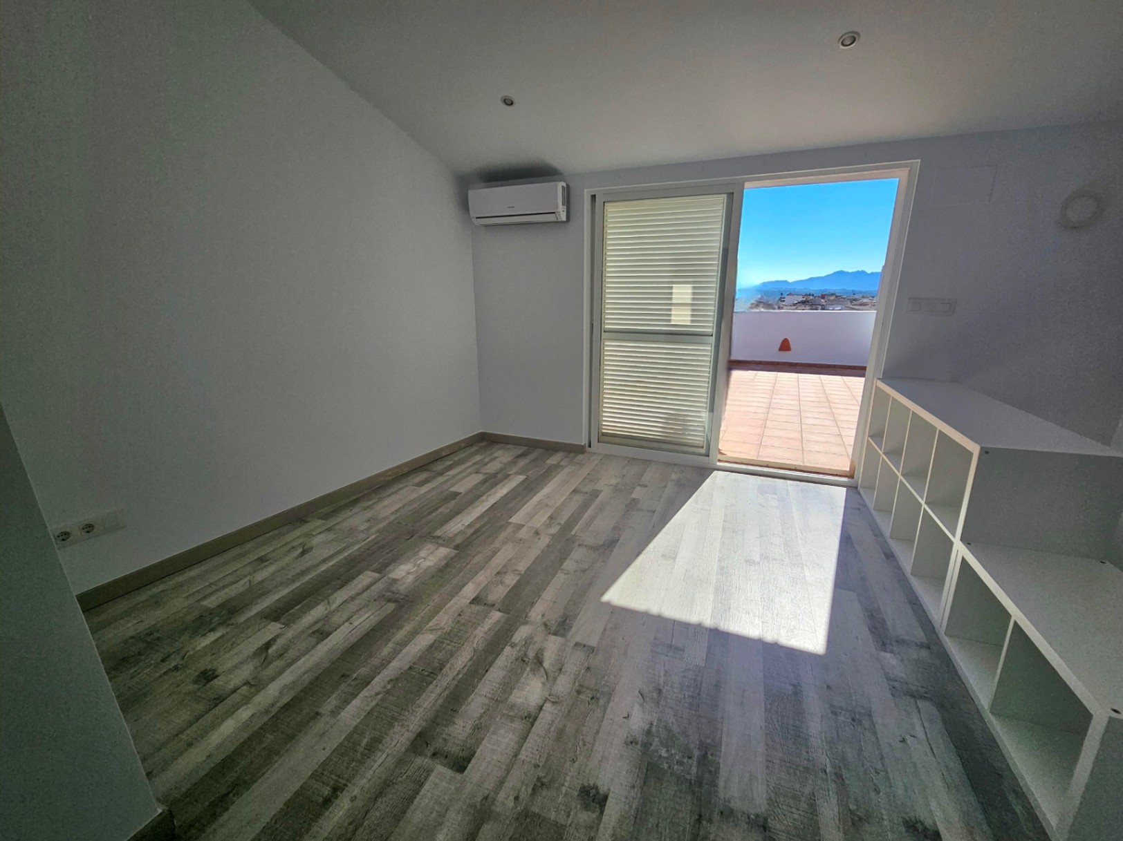 Helles Büro mit Holzboden, Klimaanlage und direktem Zugang zu einer privaten Terrasse mit Panoramablick auf die Berge.