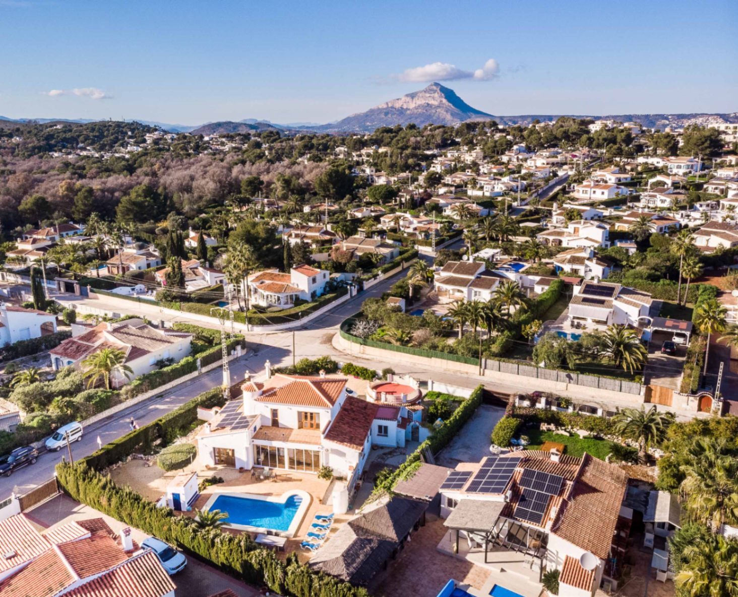 Luftbild der Villa mit privatem Pool und Solaranlage, eingebettet in die Landschaft von Jávea mit dem markanten Berg Montgó im Hintergrund.