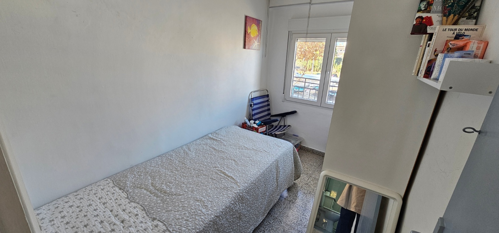 Einzelzimmer mit klassischem Terrazzoboden, einem Einzelbett und Fenster mit Blick nach draußen für eine helle Atmosphäre.