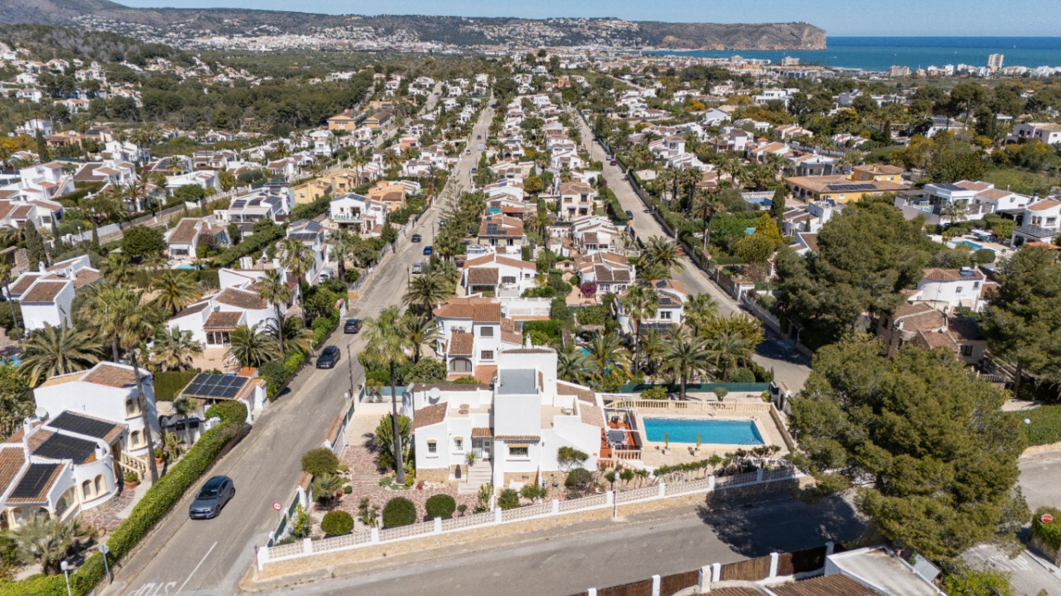 Luftaufnahme des Anwesens in Pinosol mit weißer Fassade, privatem Pool und Blick auf das Mittelmeer am Horizont von Jávea.