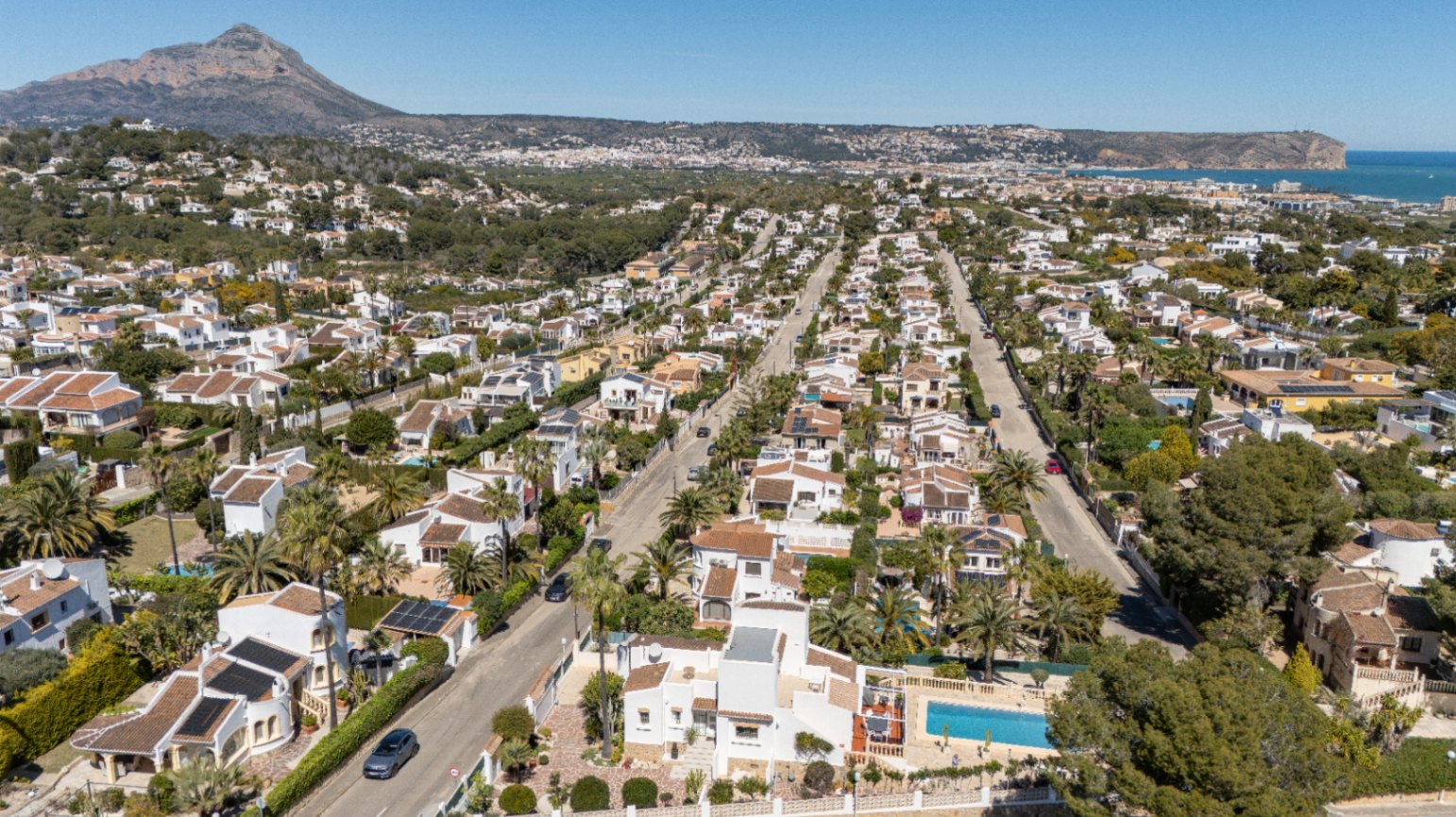 Luftaufnahme des Wohngebiets Pinosol in Jávea mit Blick auf das Mittelmeer und das beeindruckende Montgó-Massiv im Hintergrund.
