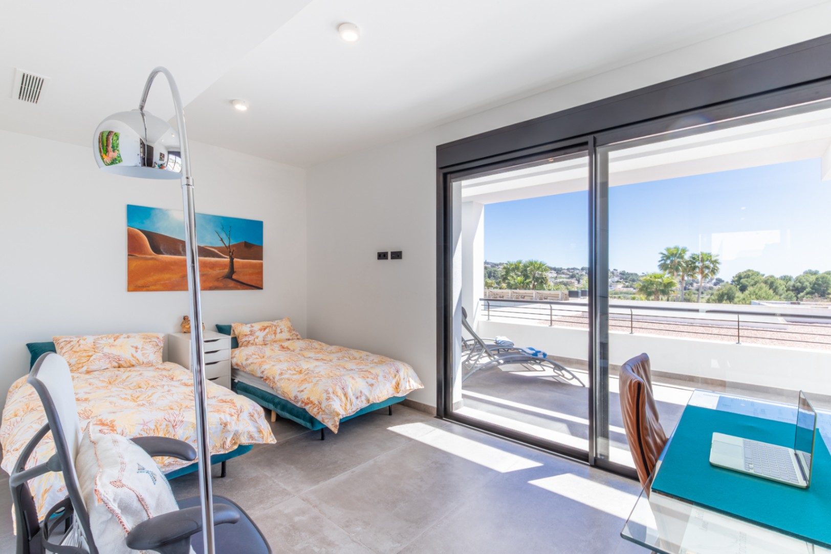 Schlafzimmer mit zwei Einzelbetten, Schreibtisch und direktem Zugang zu einer privaten Terrasse mit weitem Ausblick durch große Glasschiebetüren.