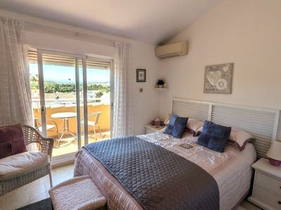 Das Hauptschlafzimmer bietet ein Doppelbett mit Lamellenkopfteil, Klimaanlage und direkten Zugang zu einer privaten Terrasse mit Sitzgelegenheiten und Weitblick.