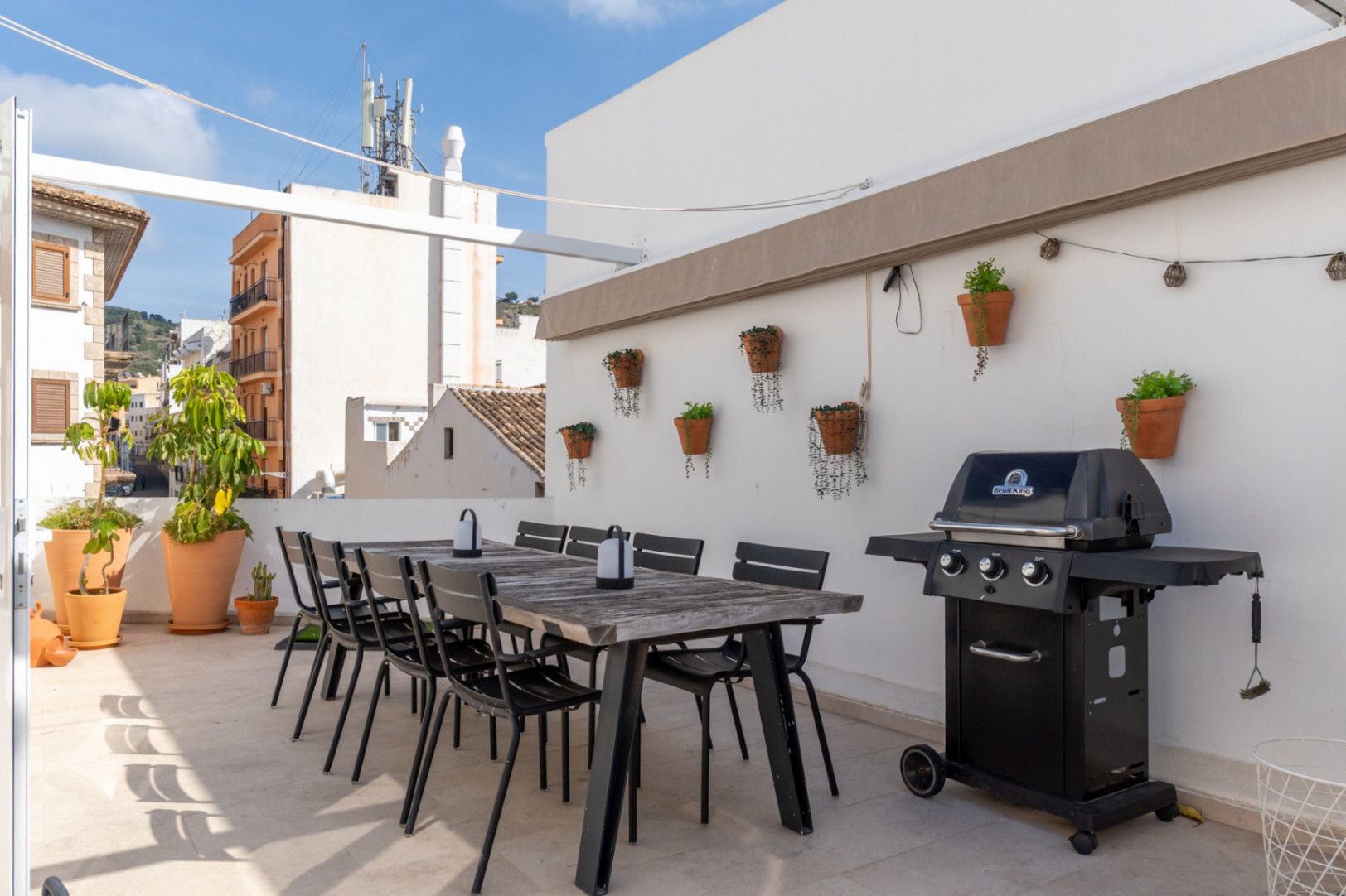 Terrasse mit Essbereich im Freien, Grill und Blick auf die Altstadt von Jávea.