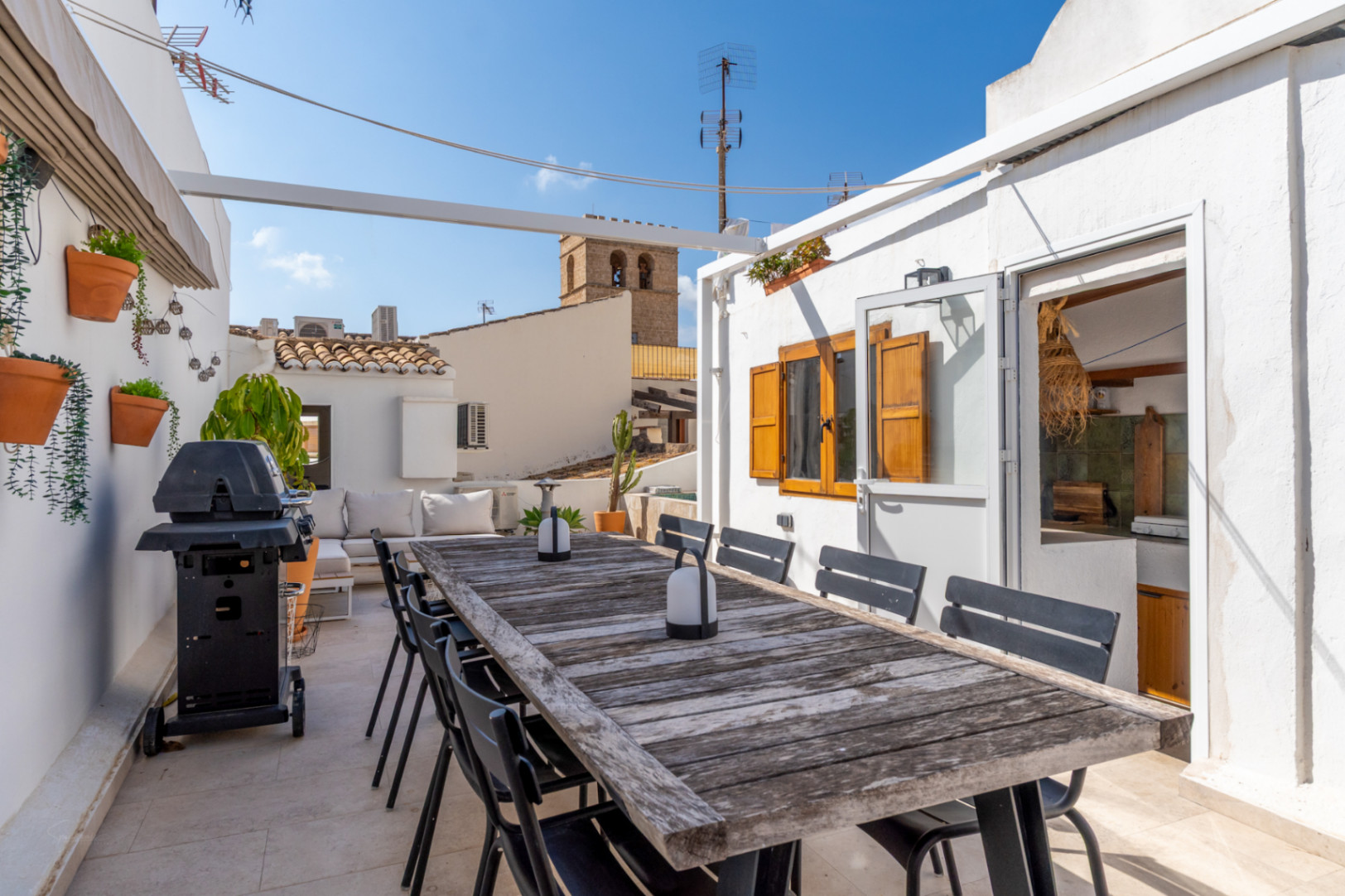 Terrasse mit rustikalem Holztisch, Grill und Blick auf die Altstadt von Jávea.
