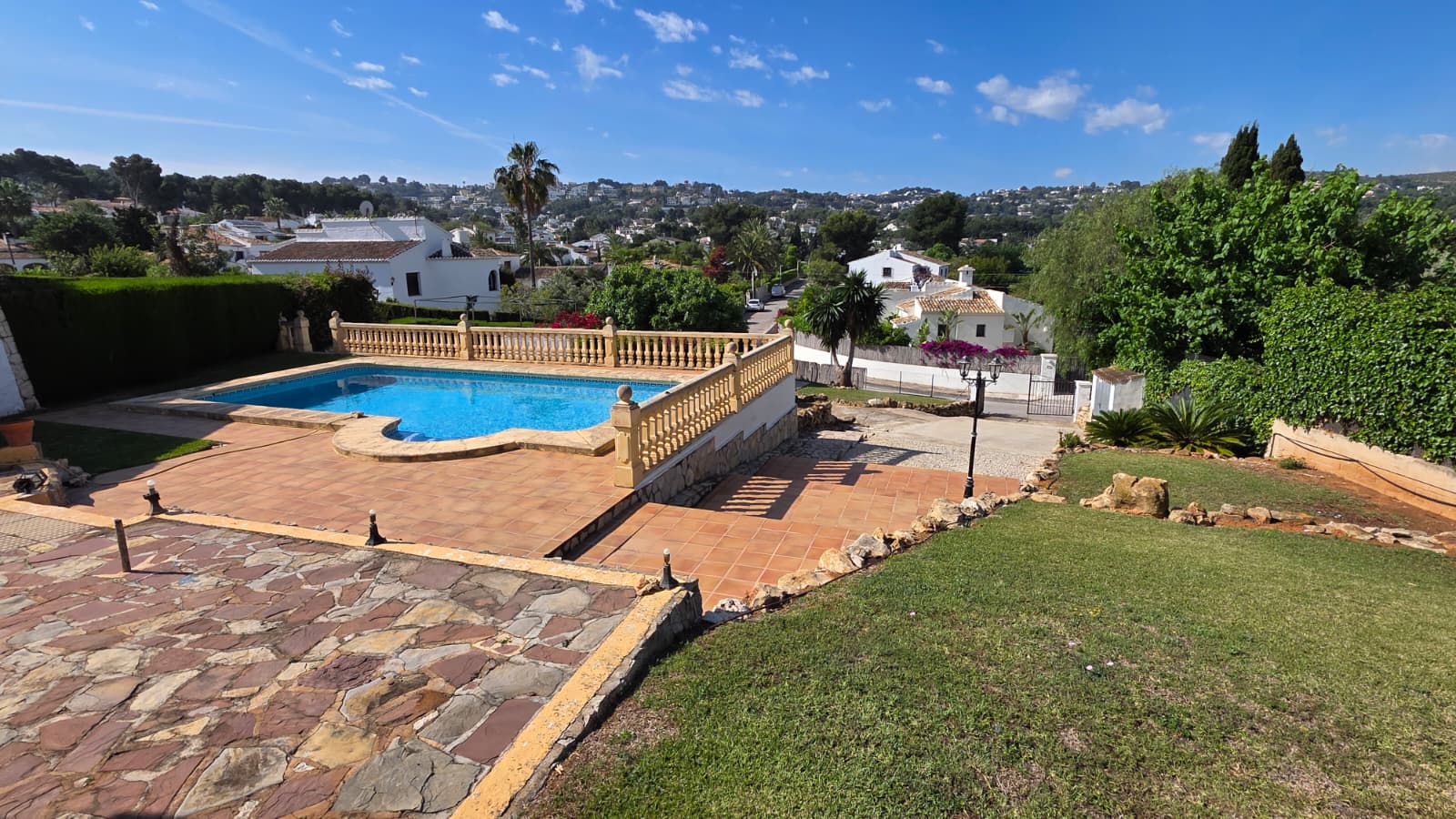 Außenpool mit klassischer Balustrade, weitläufiger Terrasse und freiem Blick über die Wohngegend El Tosalet in Jávea.