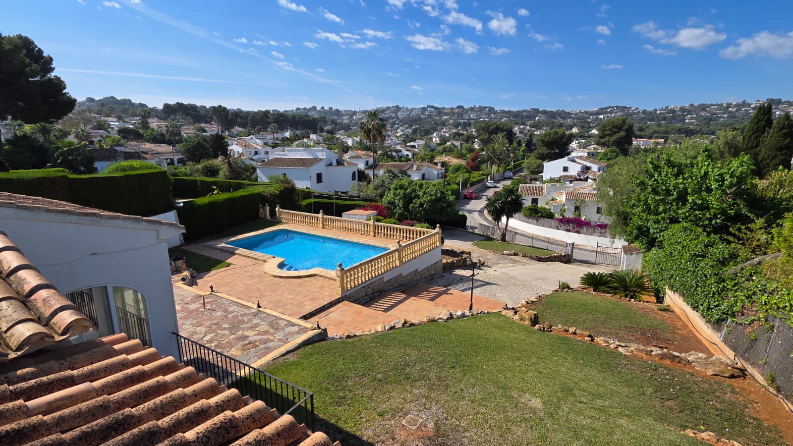 Erhöhter Blick auf den privaten Pool mit Steinbalustrade, Terrakotta-Terrasse und Gartenbereich mit weitem Ausblick über die Urbanisation El Tosalet.