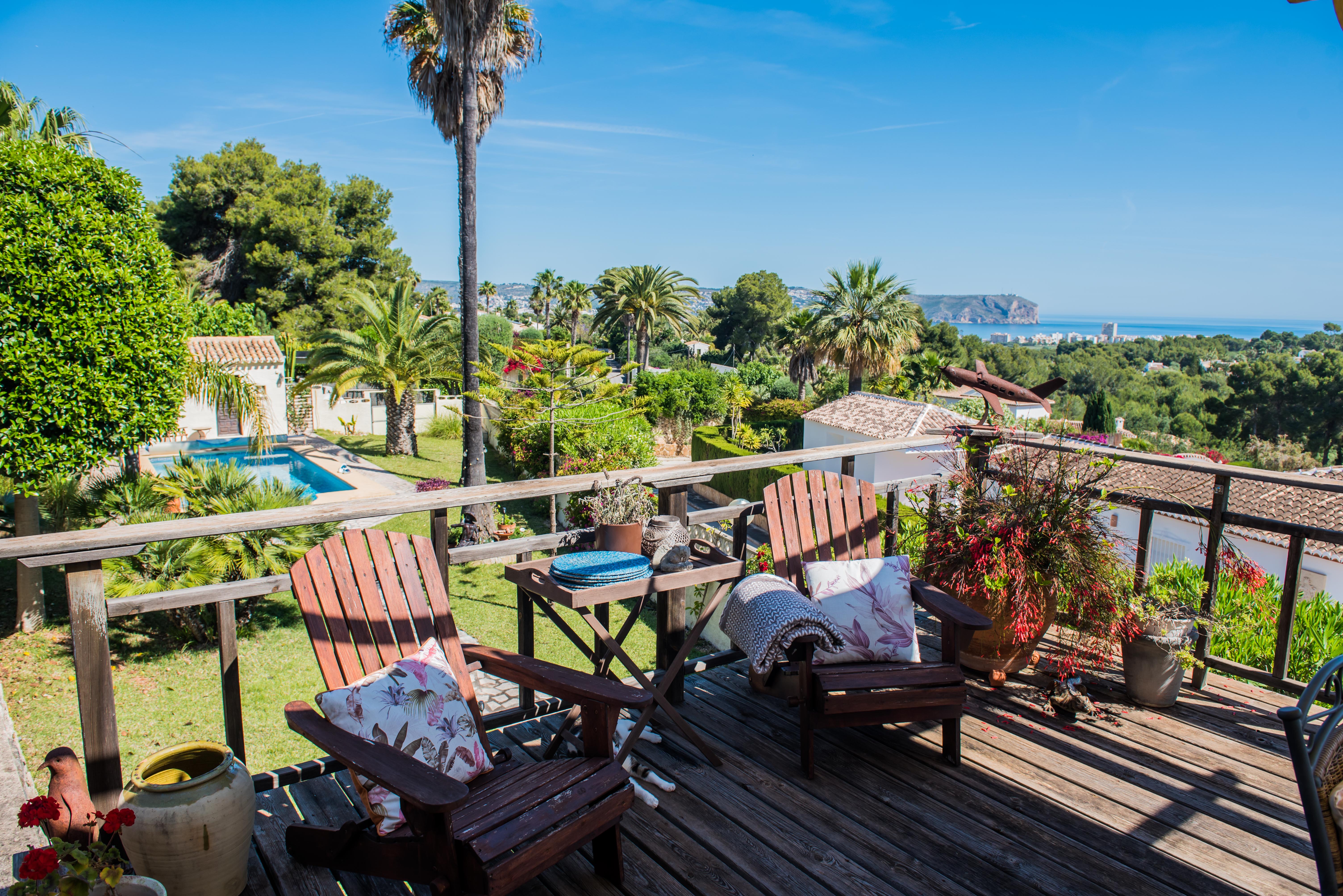 Blick von der Holzterrasse mit Adirondack-Stühlen, Gärten und Panoramablick auf das Meer in Jávea.