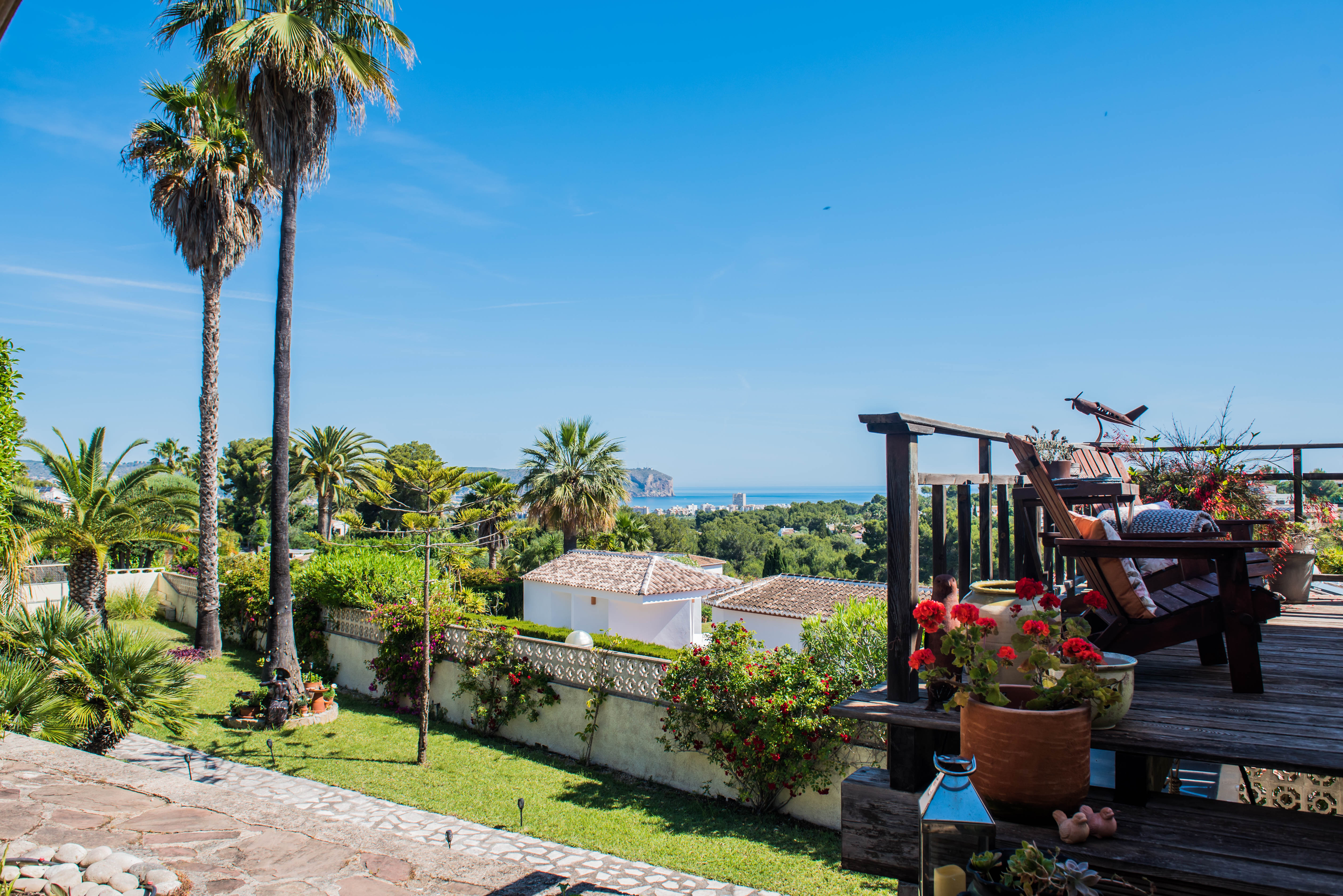 Blick von der Holzterrasse mit Bougainvillea und rustikalen Sesseln mit Blick auf das Mittelmeer.