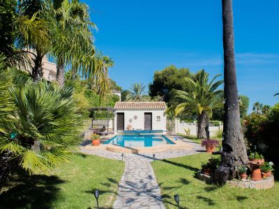 Blick auf den 8x4 m Pool mit Wärmepumpe, umgeben von Gärten und einer ausgestatteten Sommerküche in Jávea.